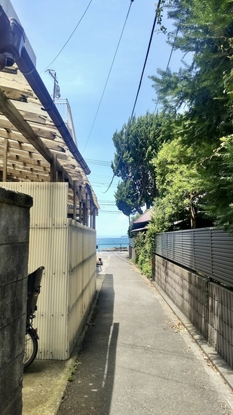 路地の写真。向こうに海が見える。