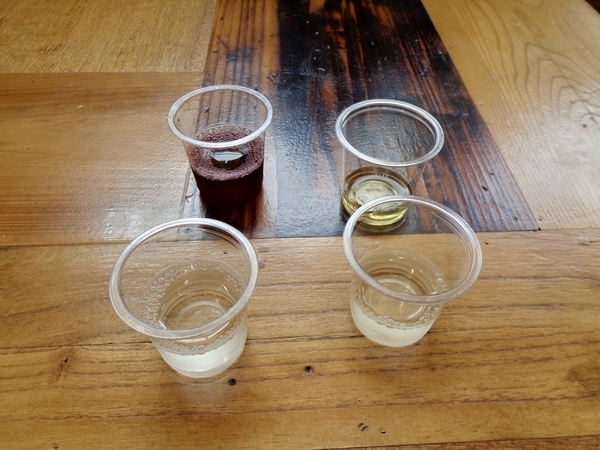地場産業センター内の写真。テーブルの上に日本酒とワインがミニカップで四杯。