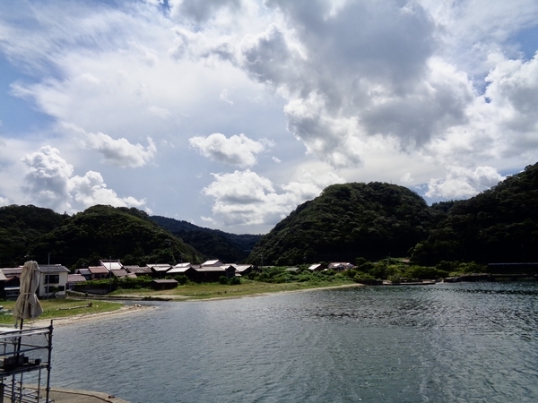 温泉津の海の写真。対岸に赤い瓦屋根の町が見える。