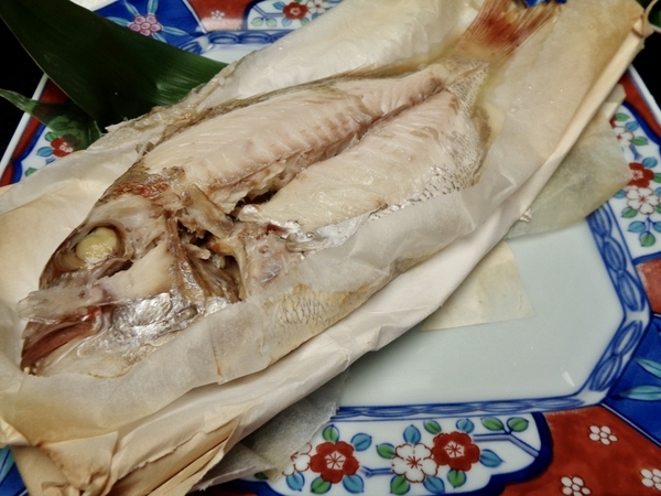 奉書焼きの紙を開いたところを撮った写真。蒸し焼きにされたまるまるとした鯛が写っている。