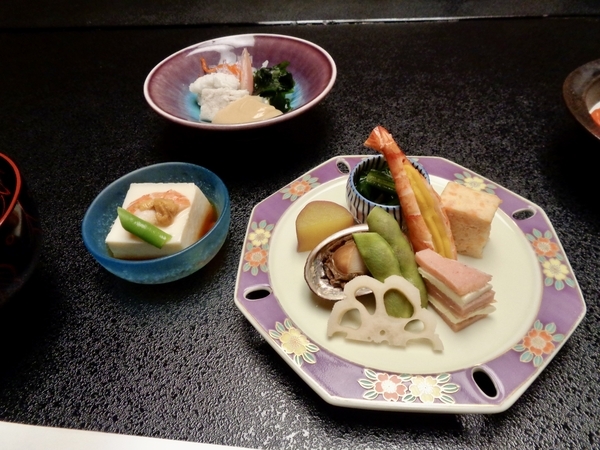 料理の写真。八寸、胡麻豆腐など前菜が三種類。