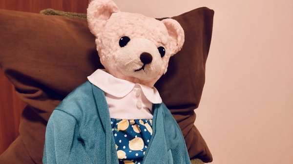 ぬいぐるみの写真。ワンピースを着て、カーディガンをはおっている。
