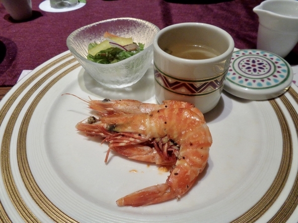 グリルしたエビの写真。サラダとスープが添えられている。