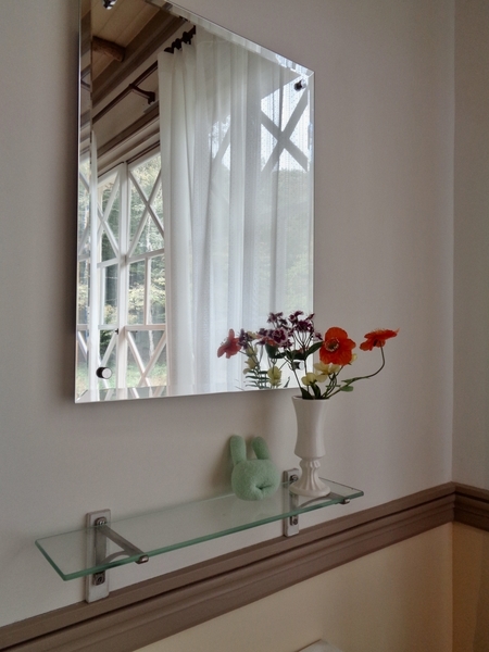 旧三笠ホテル、客室の写真。古い鏡の前に花が生けてある。