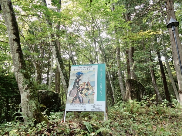 ポール・ジャクレー展のポスターを撮った写真。木立の中にある。