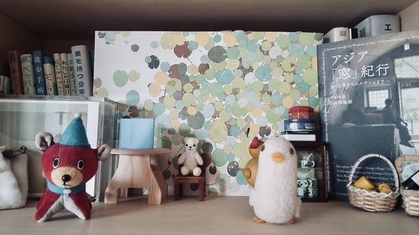 本棚の一隅を撮った写真。小さなぬいぐるみや木彫りの鳥がそこで暮らしている。
