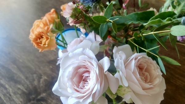 切り花の写真。手前に薄桃色の、奥にオレンジのミニバラ。