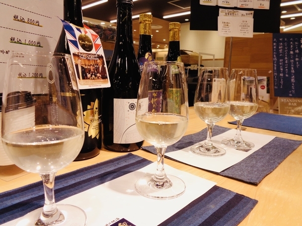 「花の舞　静岡パルシェ店」店内の写真。カウンターの上にグラスが四つ出ていて、日本酒が注がれている。