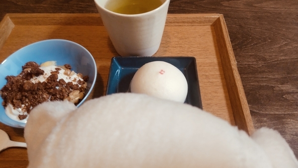 子豚のぬいぐるみの後頭部を撮った写真。むこうにあんまんが見える。