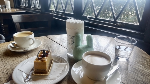 カフェ店内の写真。テーブルの上にコーヒーとケーキが出ている。