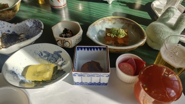 昼食の写真。テーブルの上に、小鉢がたくさん並んでいて、おいしそうなものが入っている。にこごりなど。