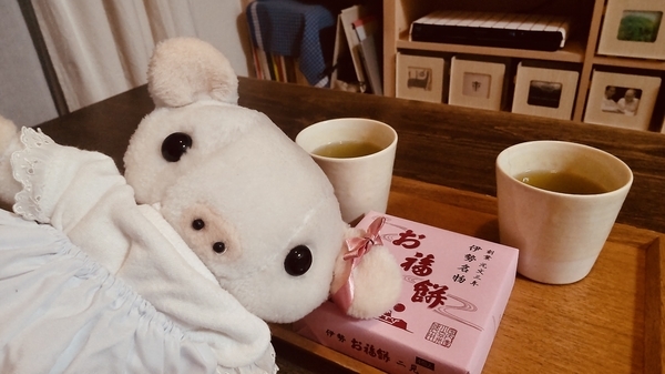 ぬいぐるみの写真。耳にりぼんをつけた子豚がティーセットの前に顔を出している。