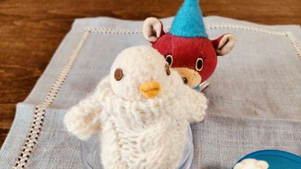 トイカプセルのカプセルに入って遊んでいる鳥のぬいぐるみを撮った写真