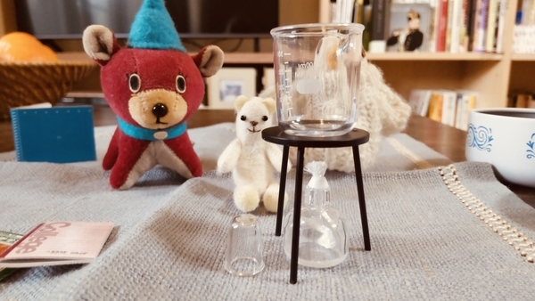 小さなぬいぐるみとミニチュアの実験器具の写真。
