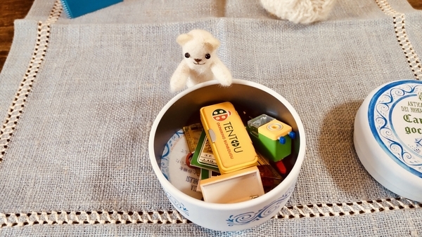 ぬいぐるみと小物入れの写真。くまが小物入れを見せている。小物入れの中身はミニチュアの文房具。