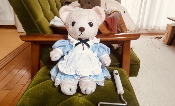 ぬいぐるみの写真。エプロンドレスを着たくまが椅子に座っている。