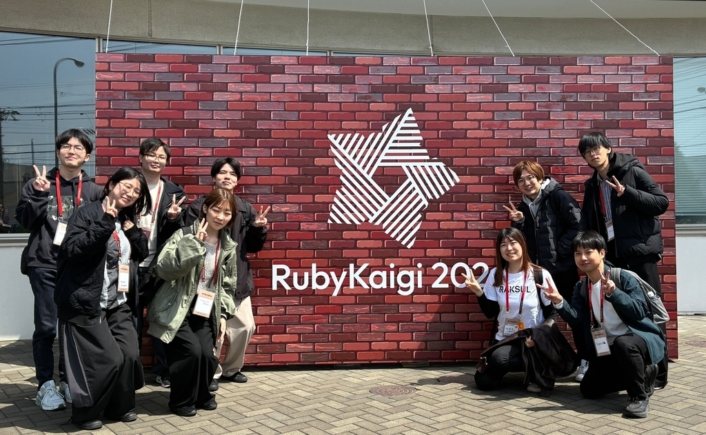 RubyKaigi 2026 看板前での Raksul メンバーの集合写真