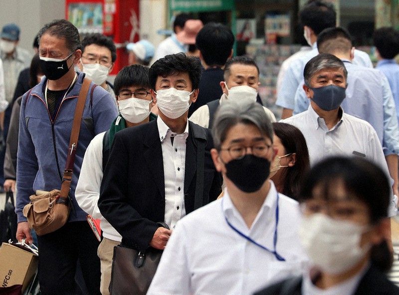 マスクをつけて通りを歩く人たち＝東京都千代田区で20日、和田大典撮影