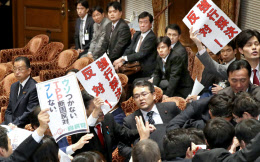 衆院ＴＰＰ特別委で採決に反対し委員長席に詰め寄る民進、共産の委員ら。左端は山本農相（４日午後）