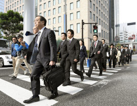 電通の東京本社に家宅捜索に向かう東京労働局の労働基準監督官ら（７日午前９時26分、東京都港区）＝共同