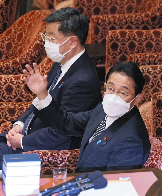 衆院議院運営委の閉会中審査で答弁のため挙手する岸田首相。奥は松野官房長官