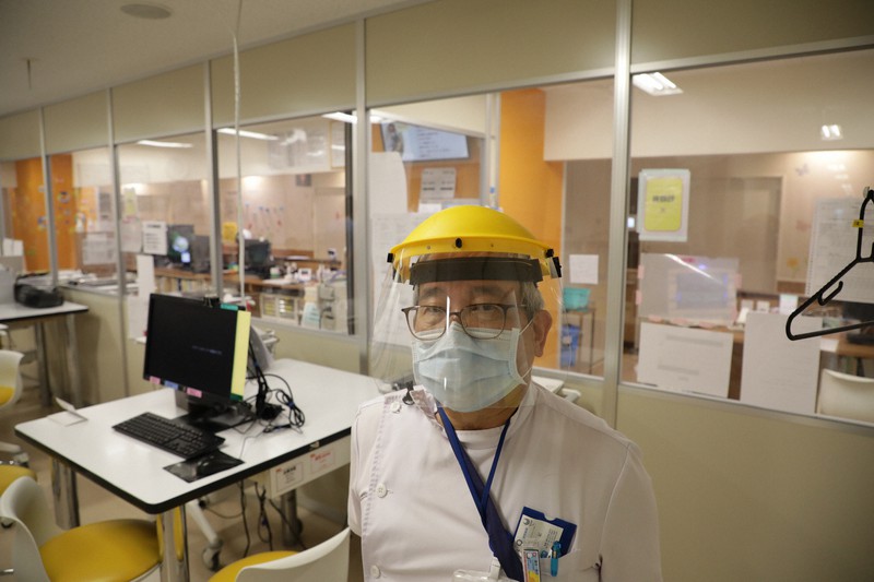 毎日新聞の取材に応じる立川相互病院の黒木啓文副院長。パーティションの奥はレッドゾーン＝東京都立川市で2021年8月2日午後4時19分、後藤由耶撮影
