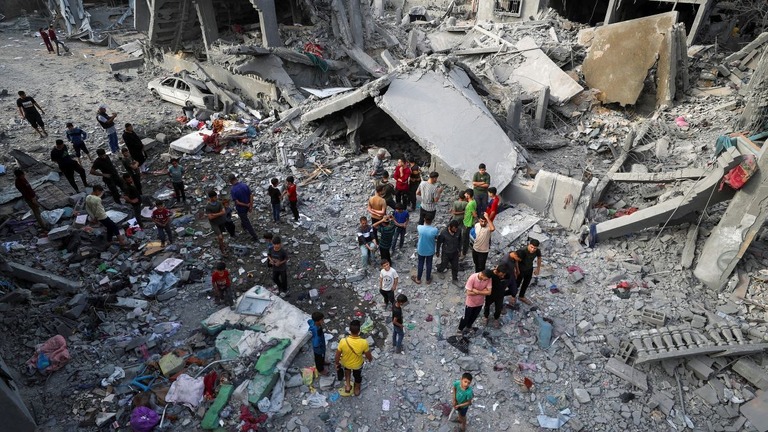 イスラエル軍による空爆の現場を調べるパレスチナの人々=18日、パレスチナ自治区ガザ地区北部/Mahmoud Issa/Reuters