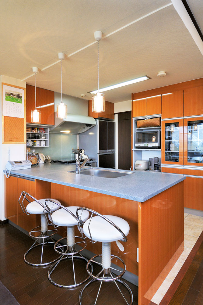 キッチン前にスツールを置けるようカウンター部を大きくしたL型キッチンの写真