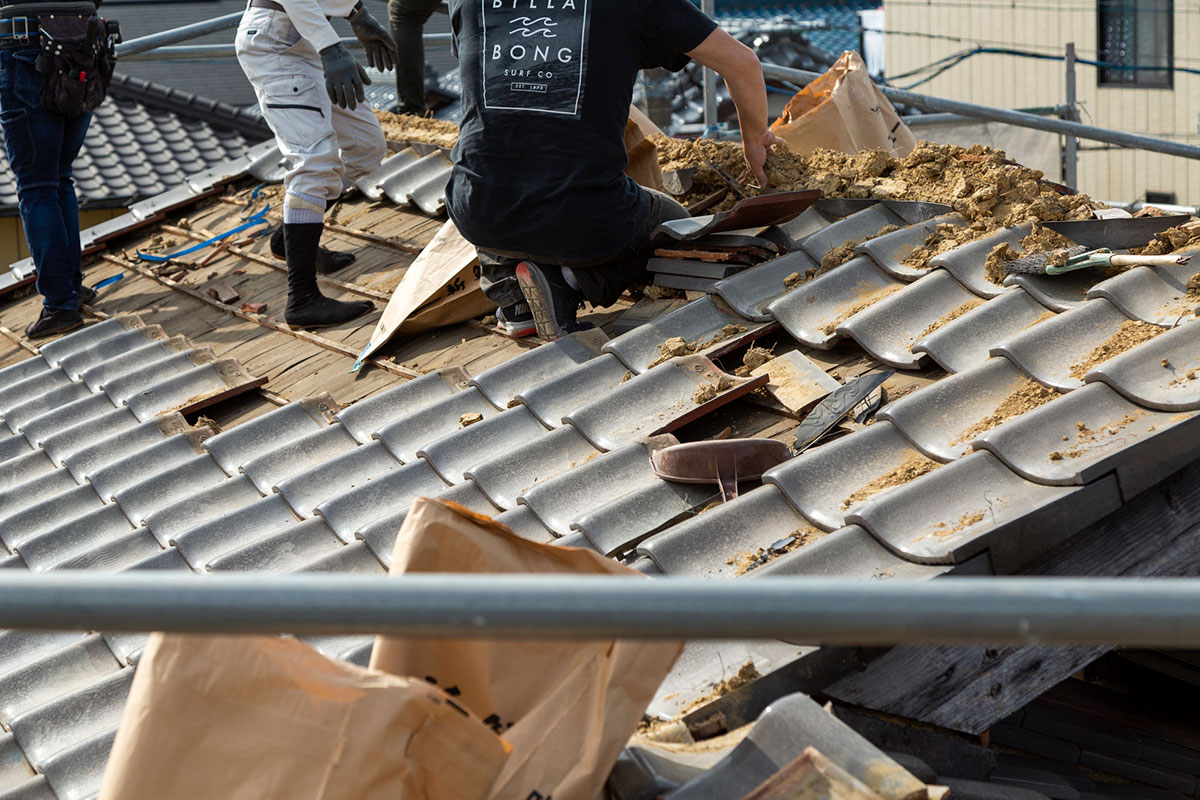 屋根葺き替えのために屋根材を撤去している写真