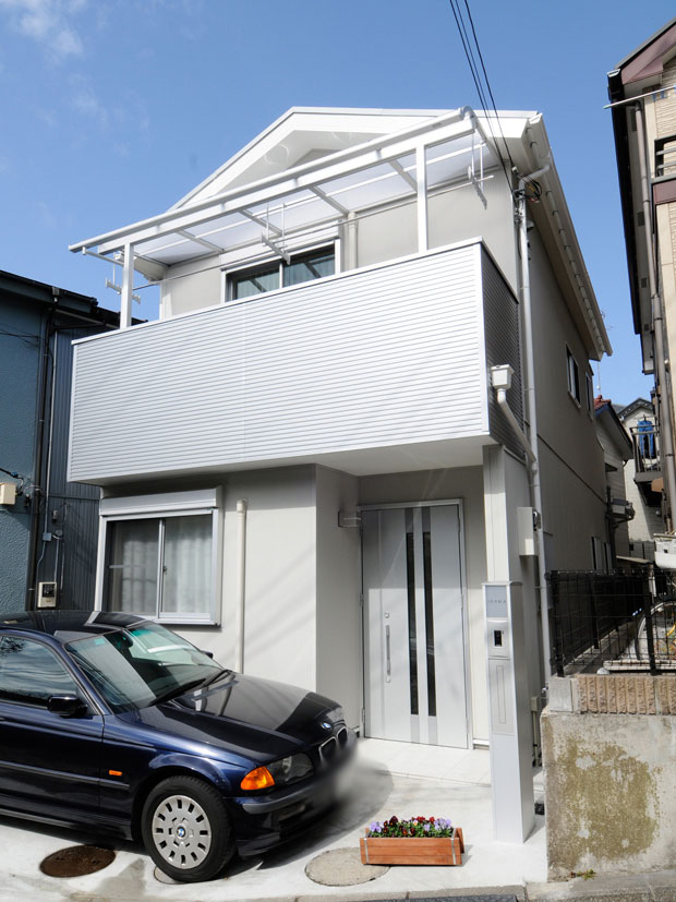 シルバー色のガルバリウム鋼板で張り替えてフレッシュな印象になった外観の写真