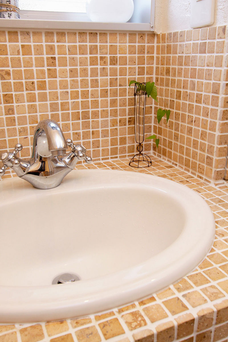 明るい色合いのタイルを基調とした洗面台