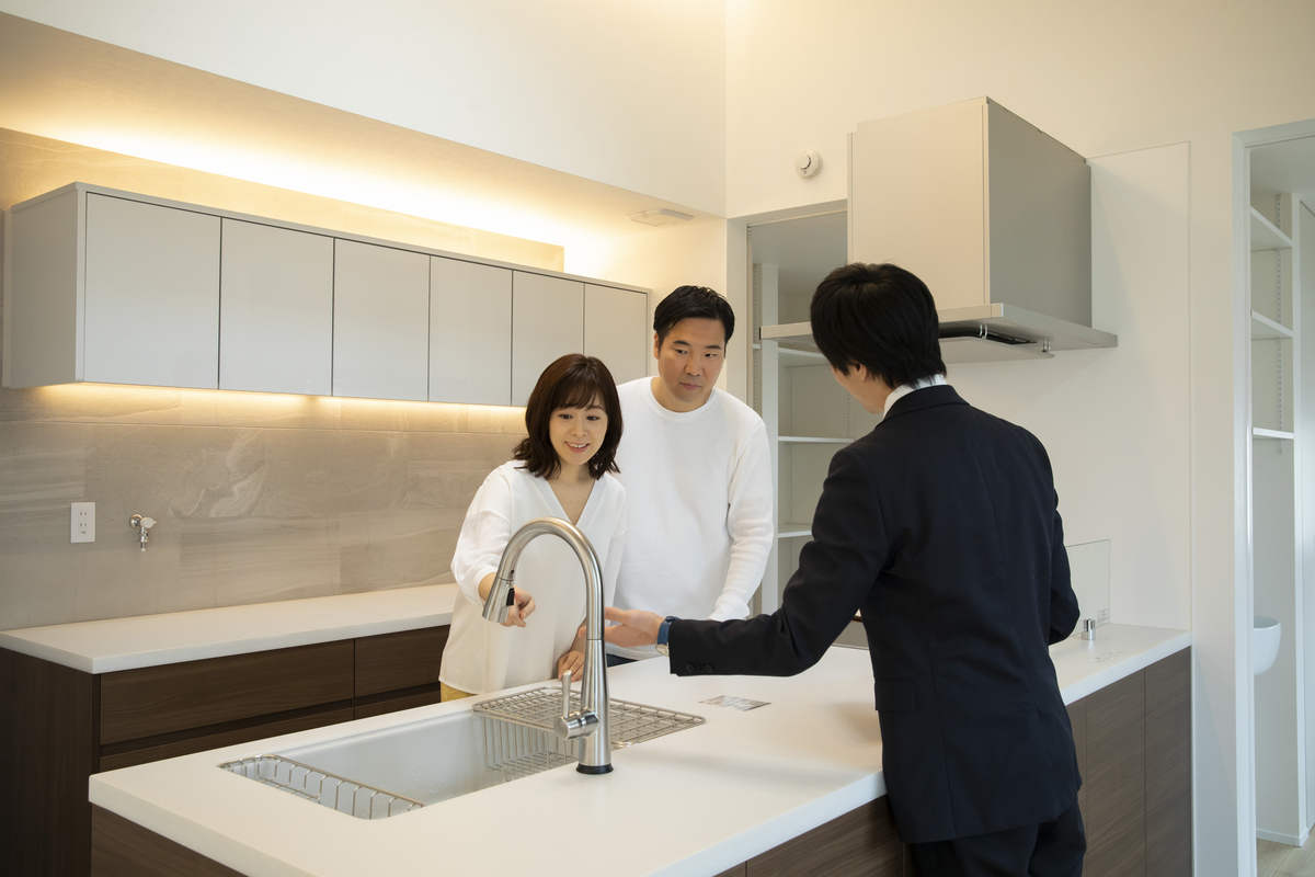 リフォーム完了後のキッチンを夫婦で確認しているイメージ