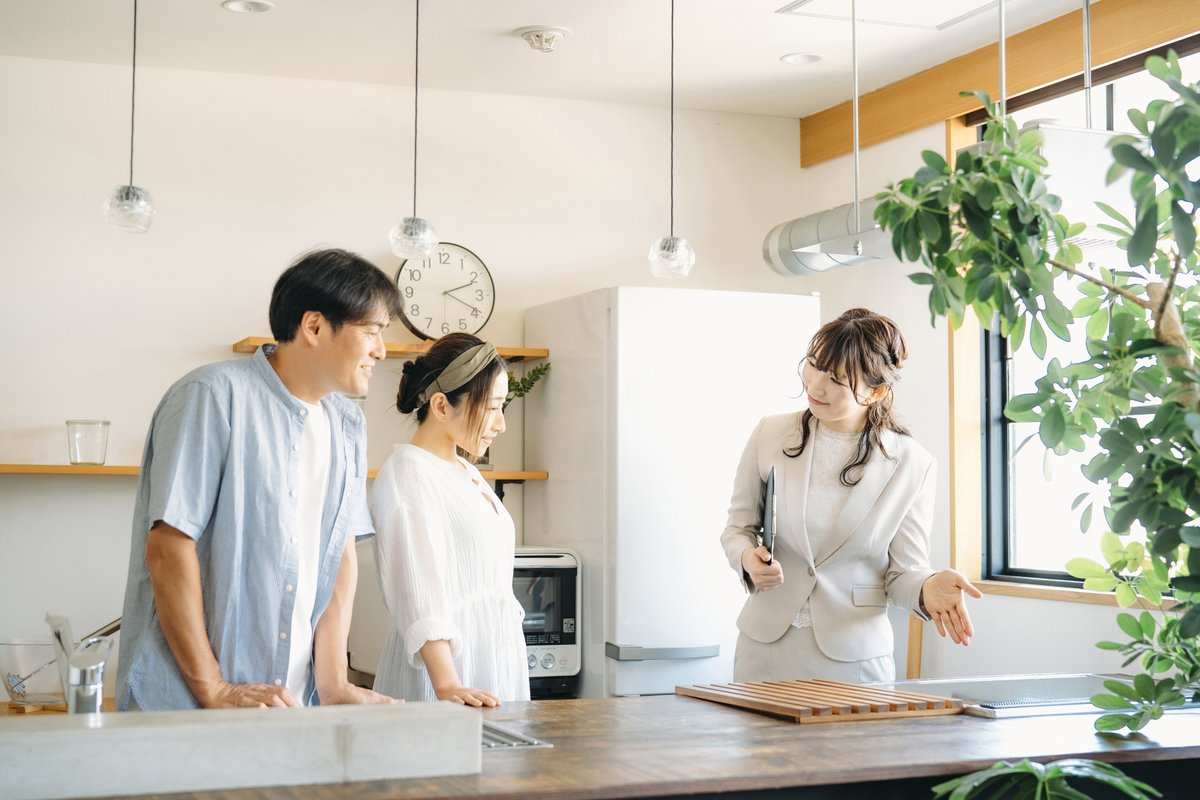 キッチン設備の説明を受ける夫婦のイメージ 