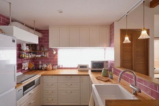 ピンクのタイルがキッチン空間のアクセントに