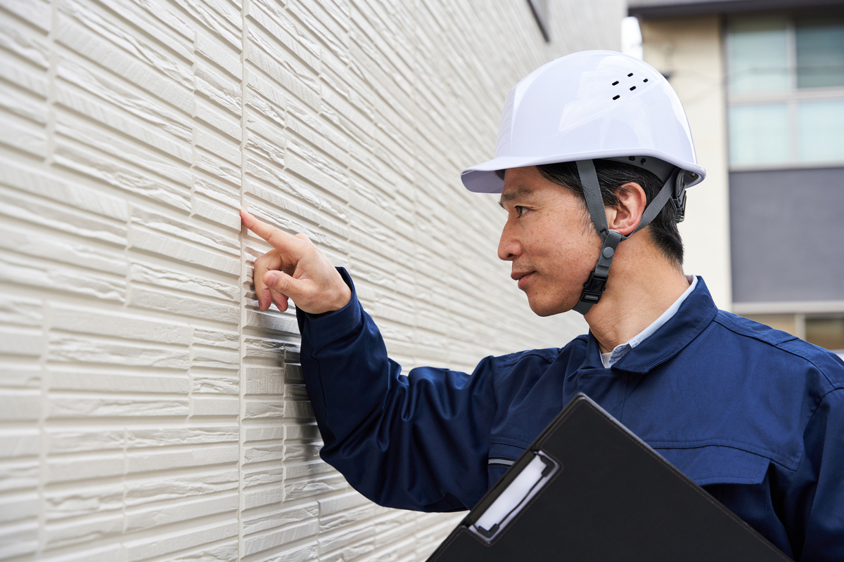 サイディングのコーキングをチェック中の写真