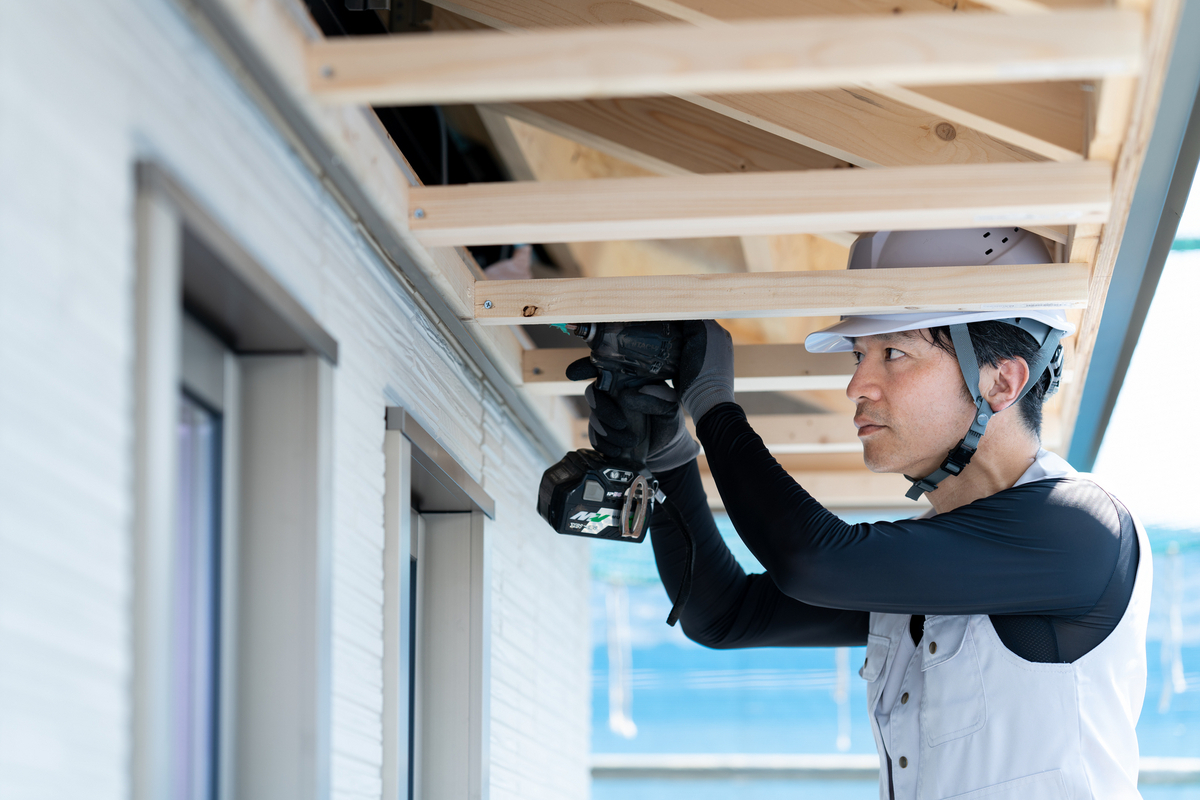 屋根の修繕を行う職人のイメージ