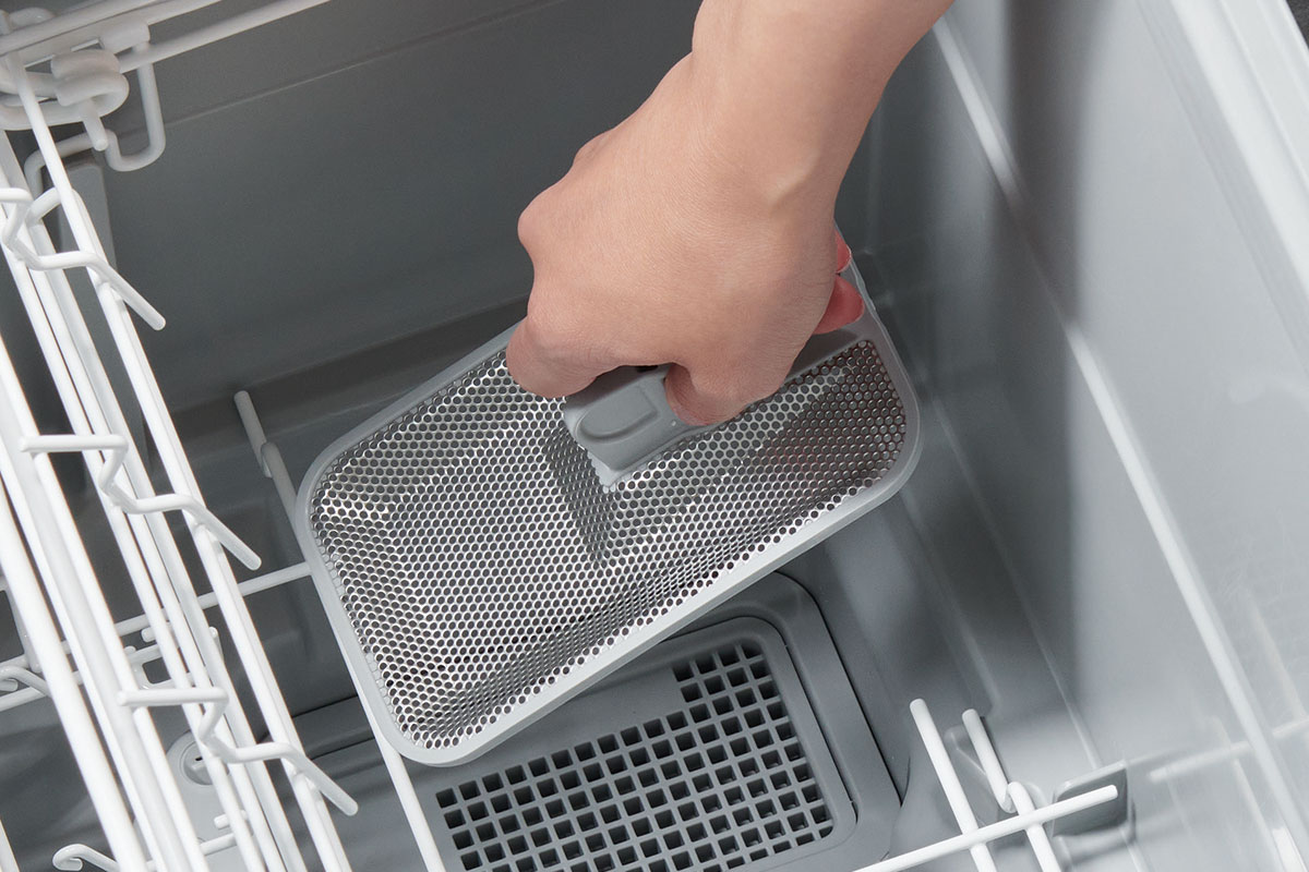 食洗機の残さいフィルターに溜まったゴミを捨てるイメージ
