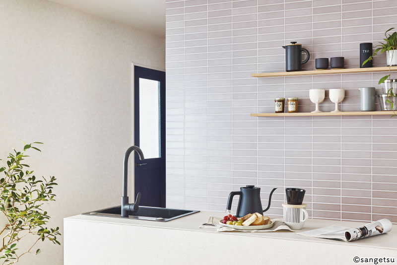 グレーのタイルデザインの壁紙を配したキッチン