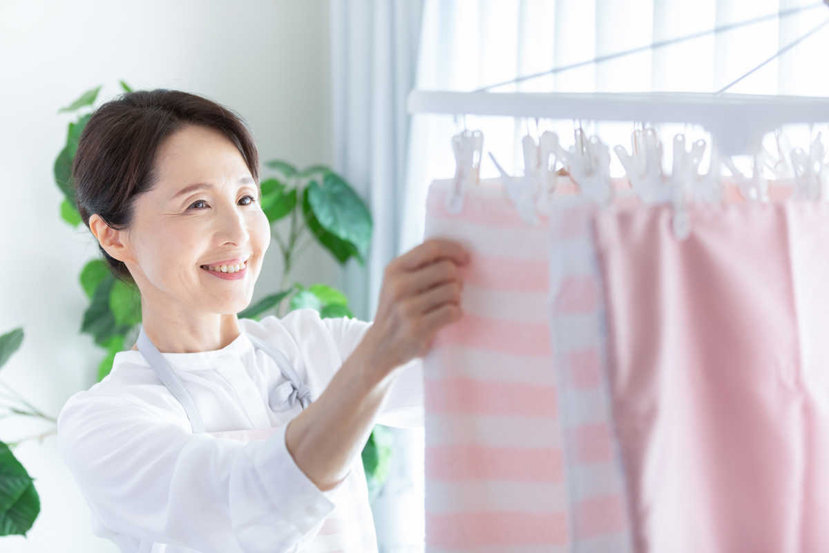 洗濯物を部屋干しする女性のイメージ