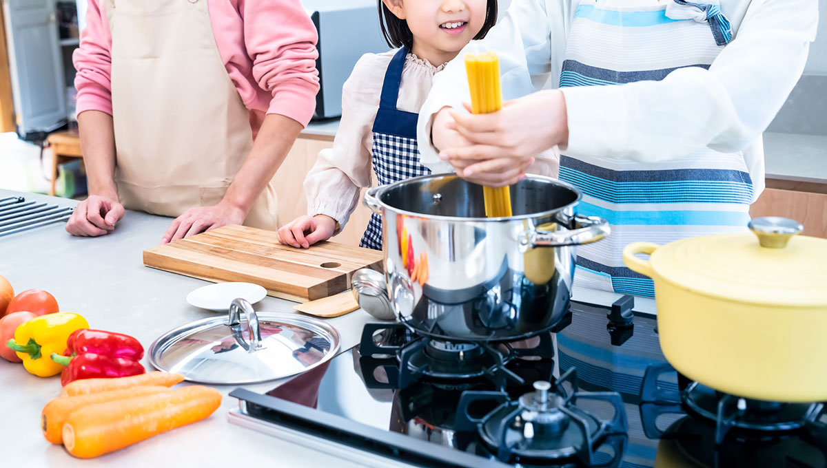 奥行きのあるワークトップで料理をする家族のイメージ