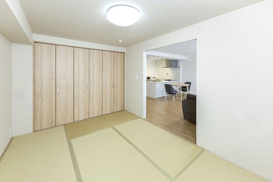 LDKに隣接する和室からキッチンが見える画像