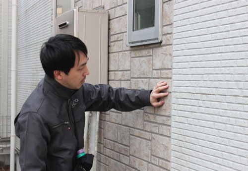 外壁のチェックをするホームインスペクターの画像