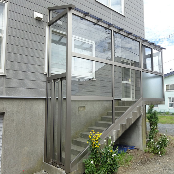 玄関階段を囲んだ風除室の写真