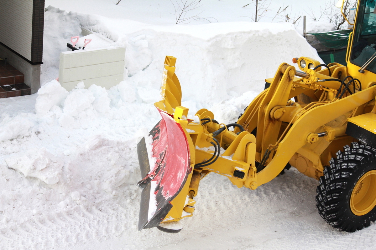 車道に積もった雪を車道脇へ寄せる除雪車の画像