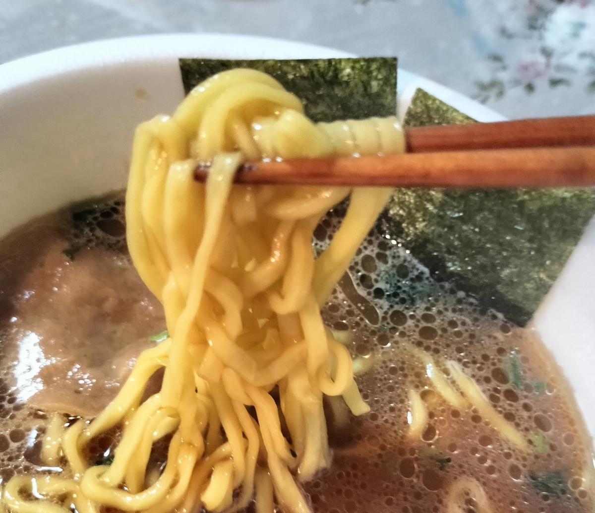 箸で持ち上げた麺の写真
