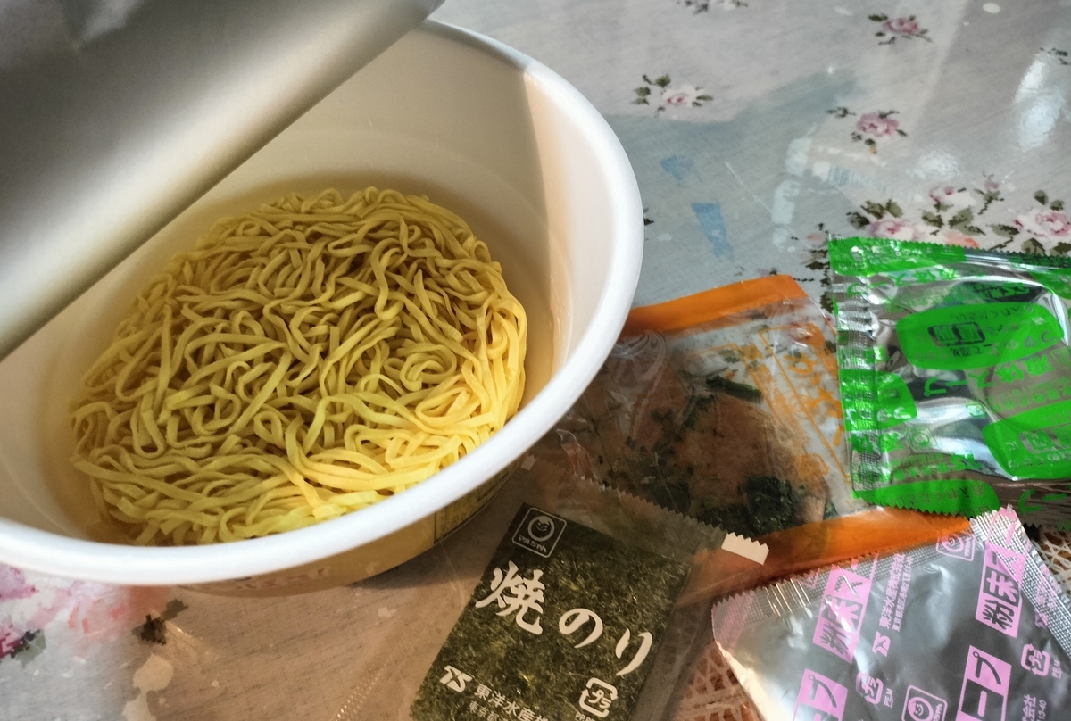 開封したカップ麺と小袋4つの写った写真