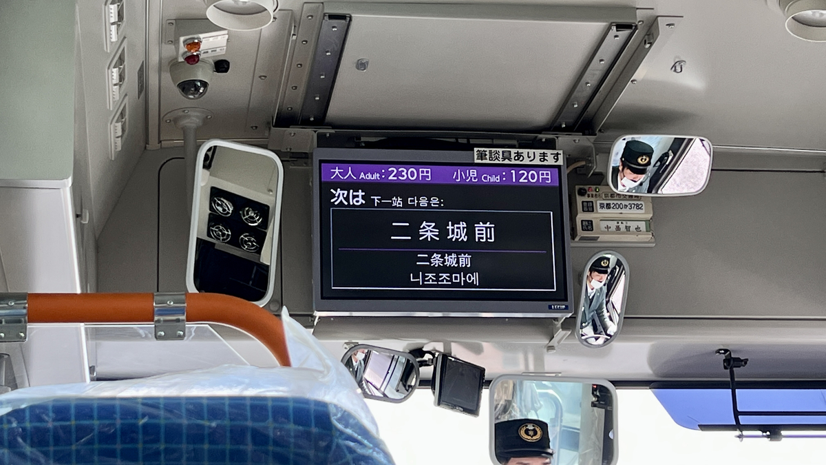 バス内の案内電光掲示板に「次は二条城前」と表示されている
