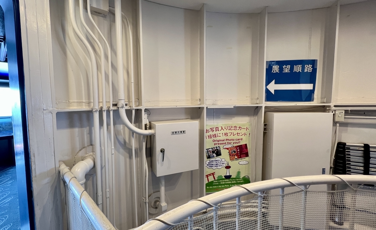 展望順路の案内看板が示す展望室への通路と記念写真カードの案内ポスター