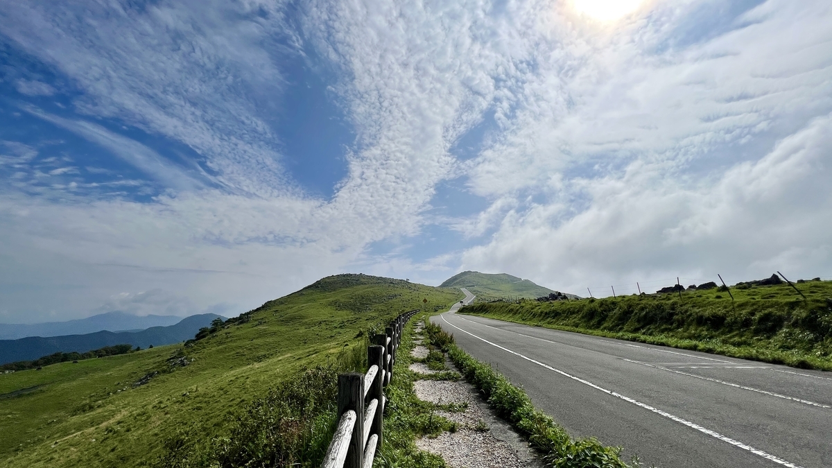 四国カルストの稜線を走る道と広がる雲空のドライブ風景