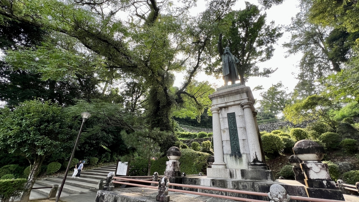 木立に囲まれた場所に立つ板垣退助の銅像とその台座